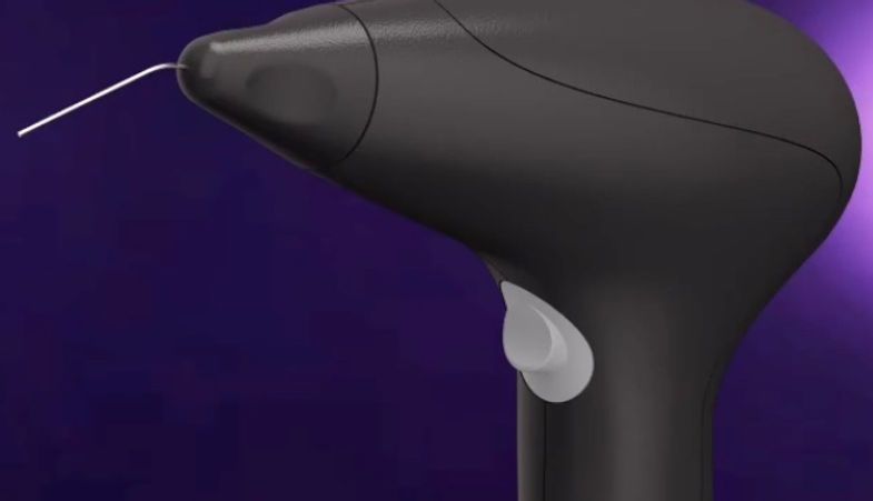 A close up of a black hair removal device on a purple background.