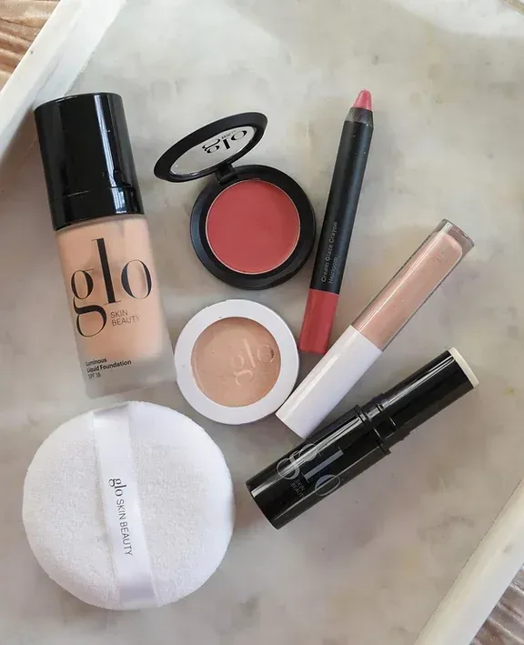 A tray of makeup including a bottle of glo foundation