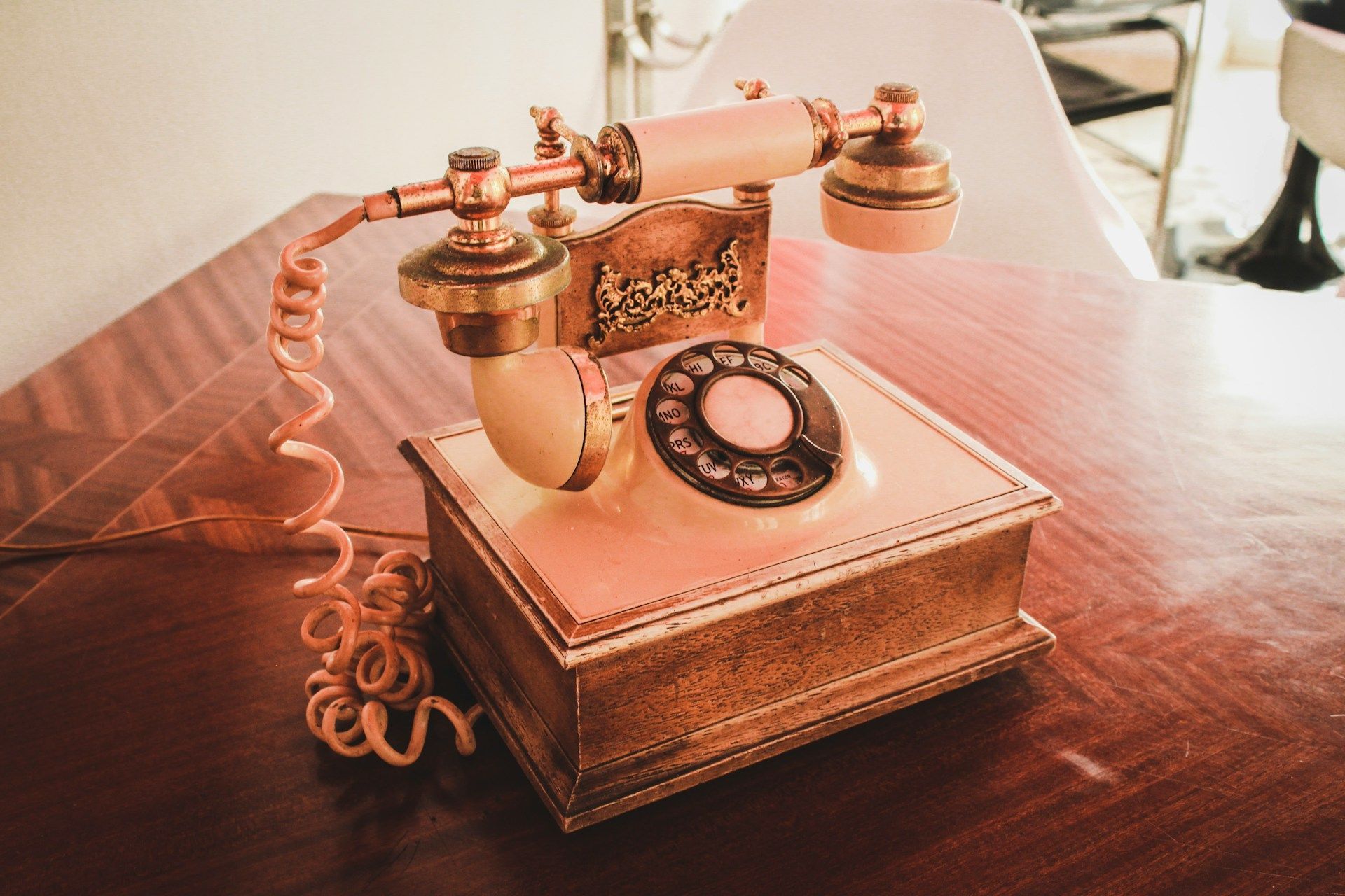 Um telefone antigo está sobre uma mesa de madeira.