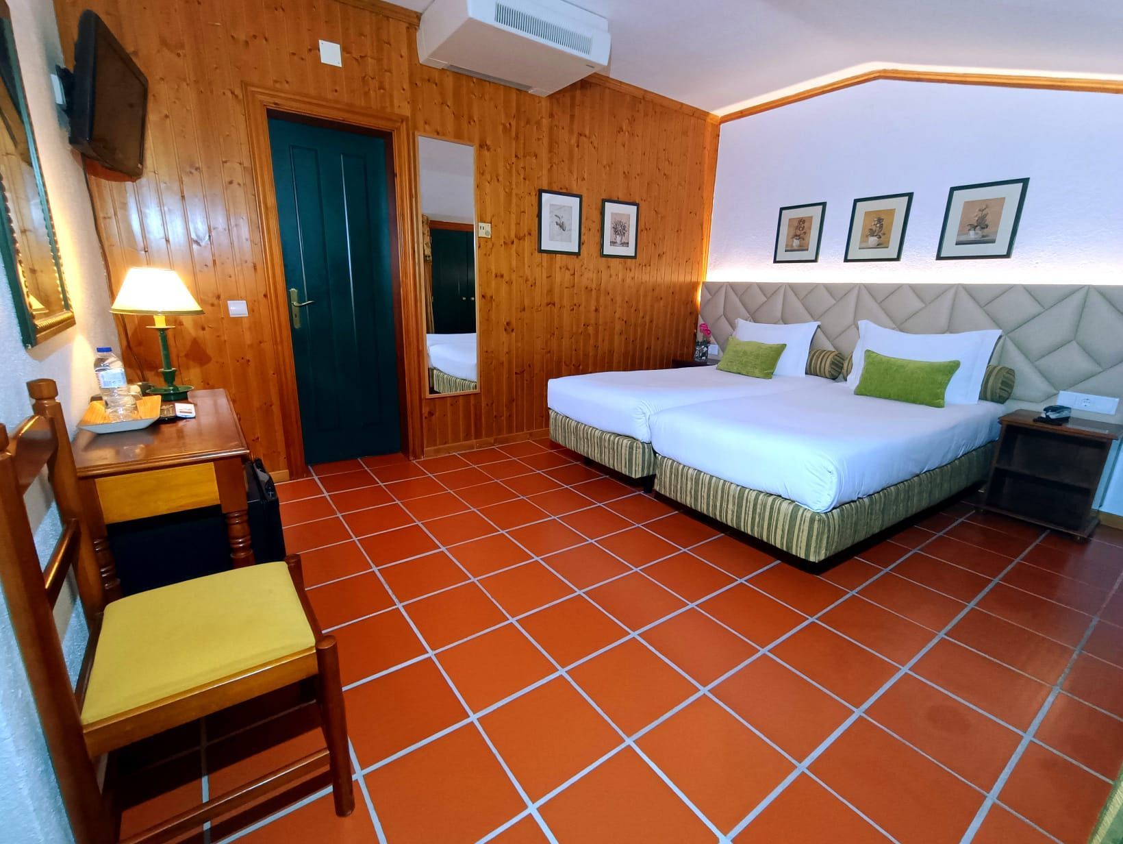 Um quarto de hotel com duas camas e uma cadeira Hotel El Rei Dom Manuel