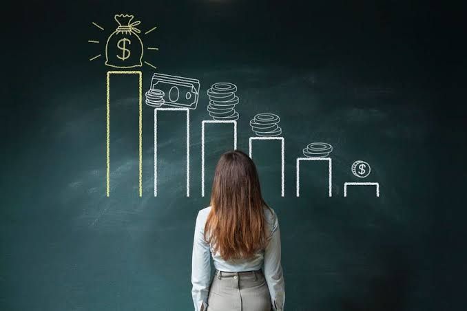 Woman facing a chalkboard with a rising bar graph and money icons, illustrating financial growth