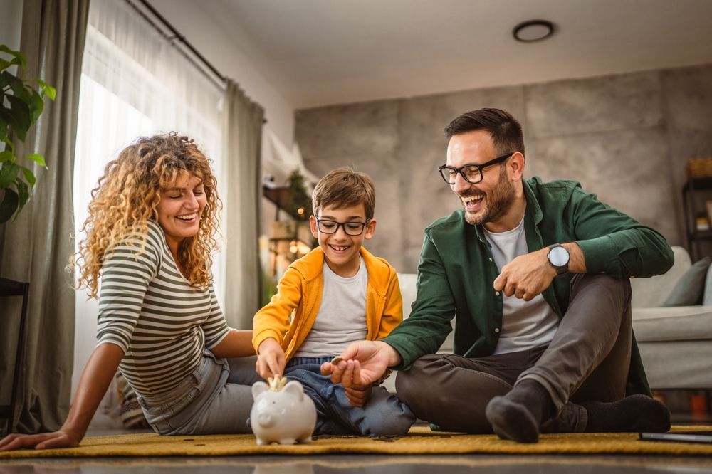 Three people sitting on the floor playing with a small white rabbit in a cozy living room