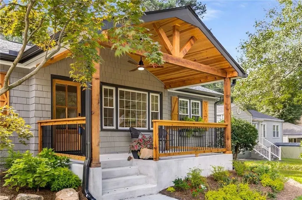 A small house with a wooden porch and stairs.