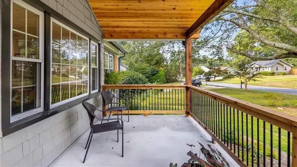 There is a ceiling fan on the porch of a house.
