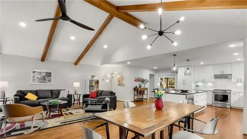 A living room with a table and chairs and a ceiling fan