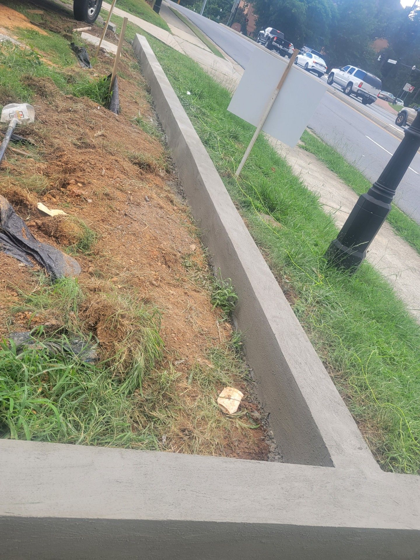 A concrete curb is being built on the side of the road.