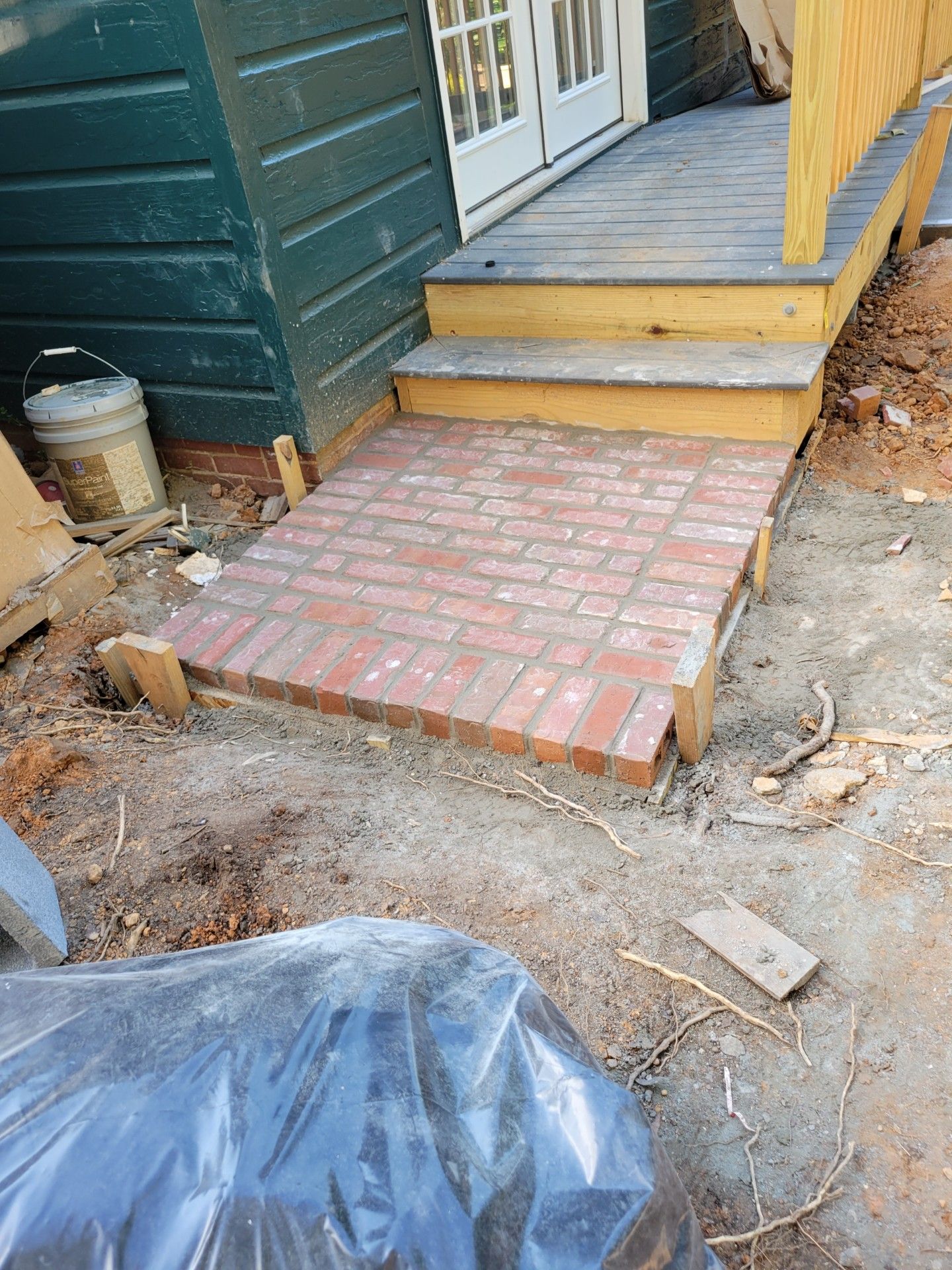 A brick walkway is being built in front of a house.