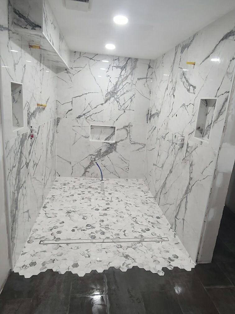 A bathroom with marble tiles on the walls and floor.