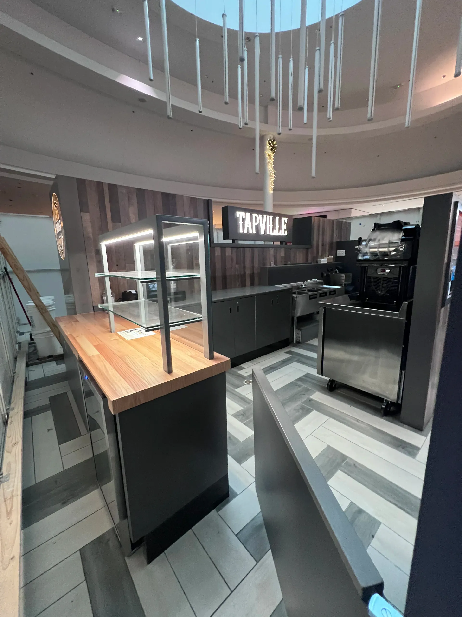 A restaurant with a wooden table and stainless steel appliances.
