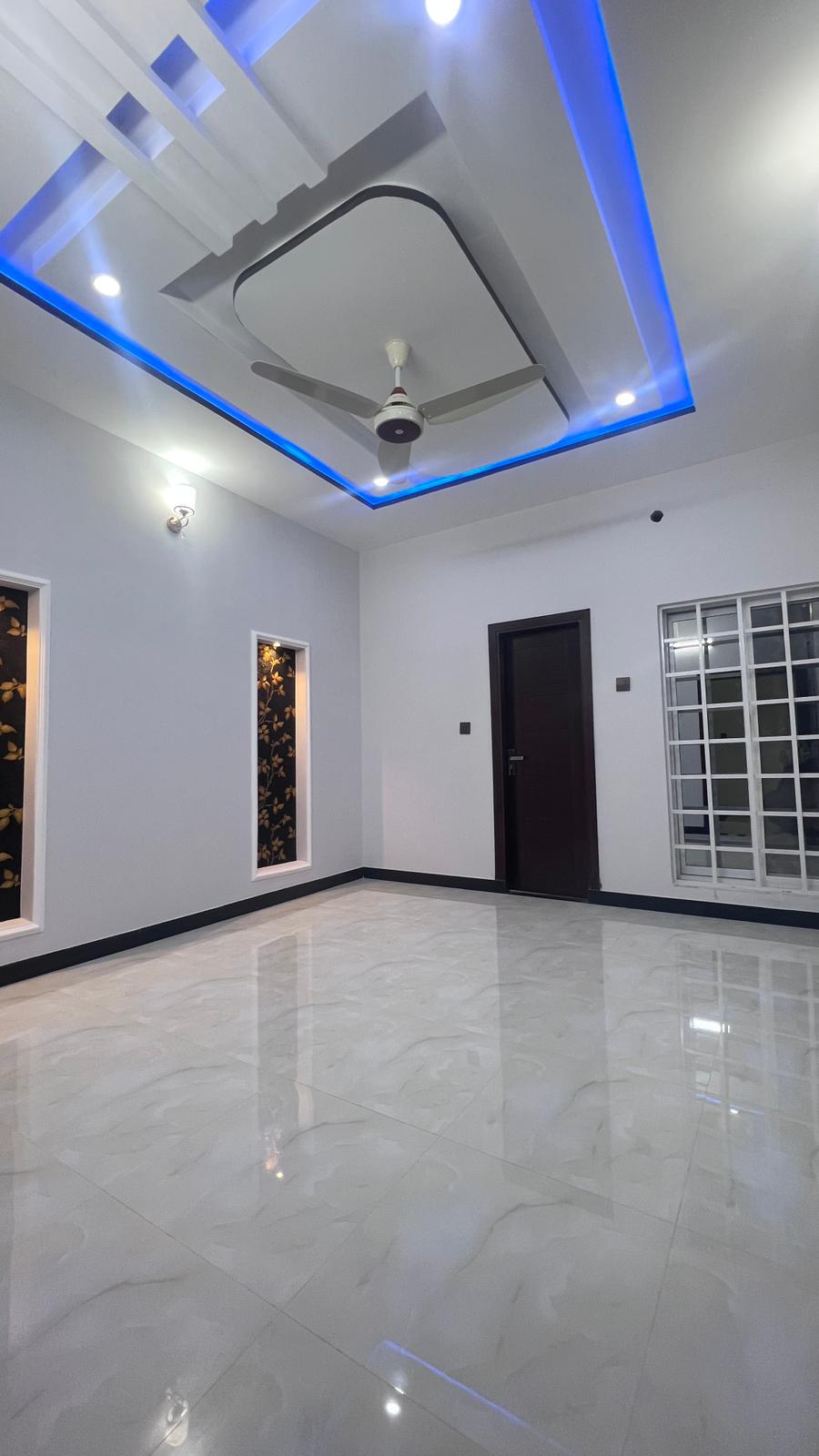 An empty room with a ceiling fan and a door.