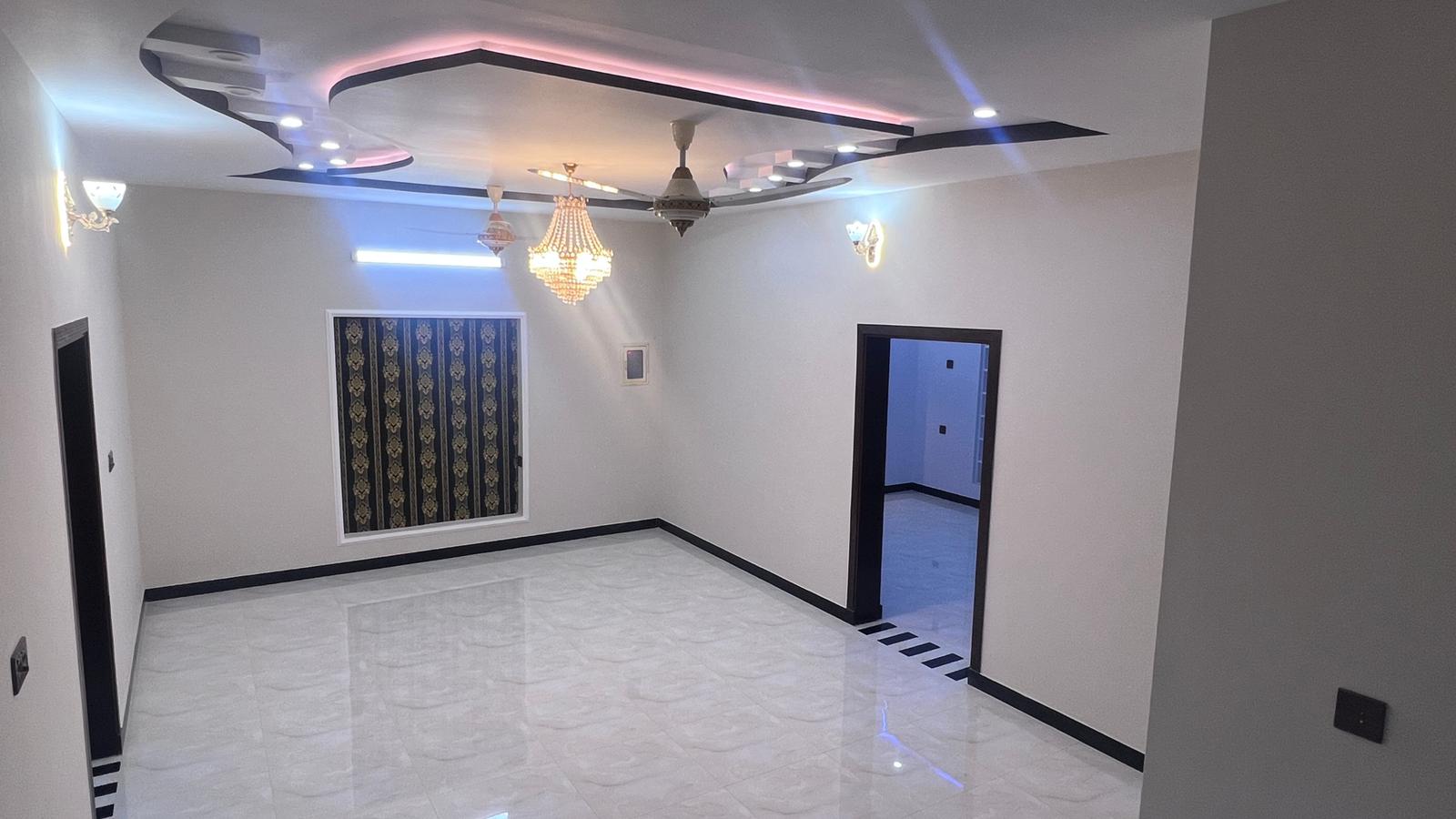 An empty room with a ceiling fan and a door