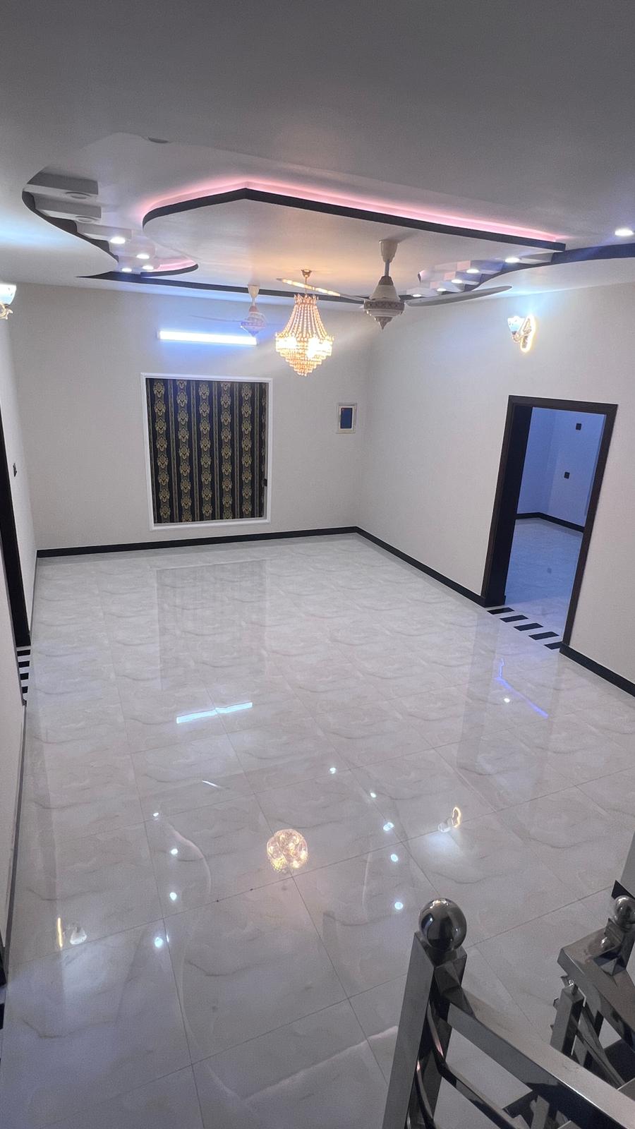 A large empty room with a staircase and a ceiling fan.
