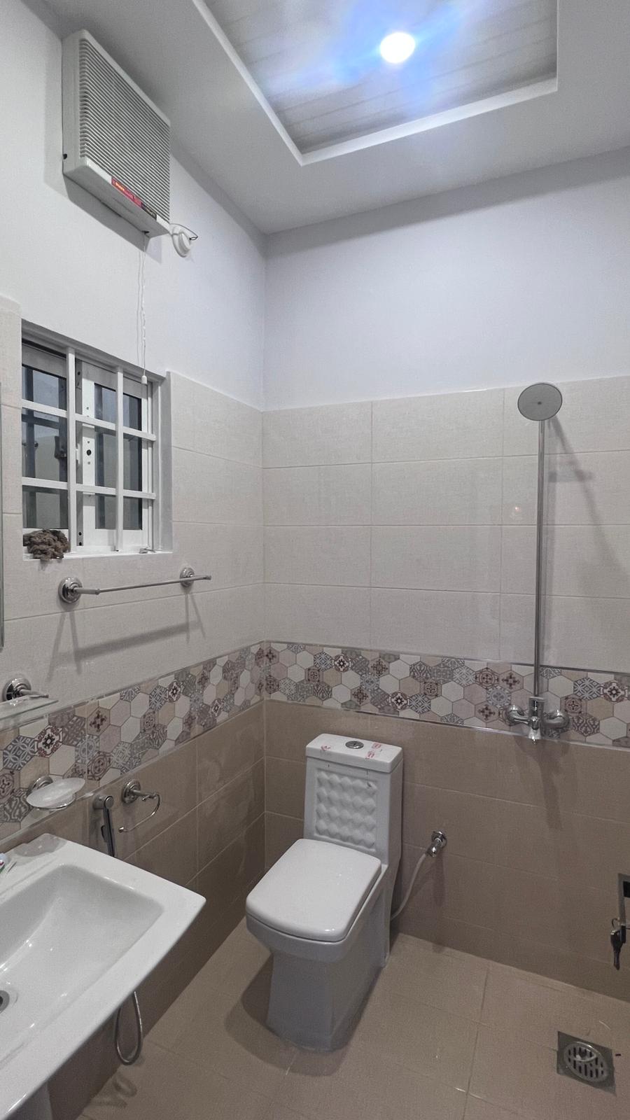 A bathroom with a toilet , sink , and shower.