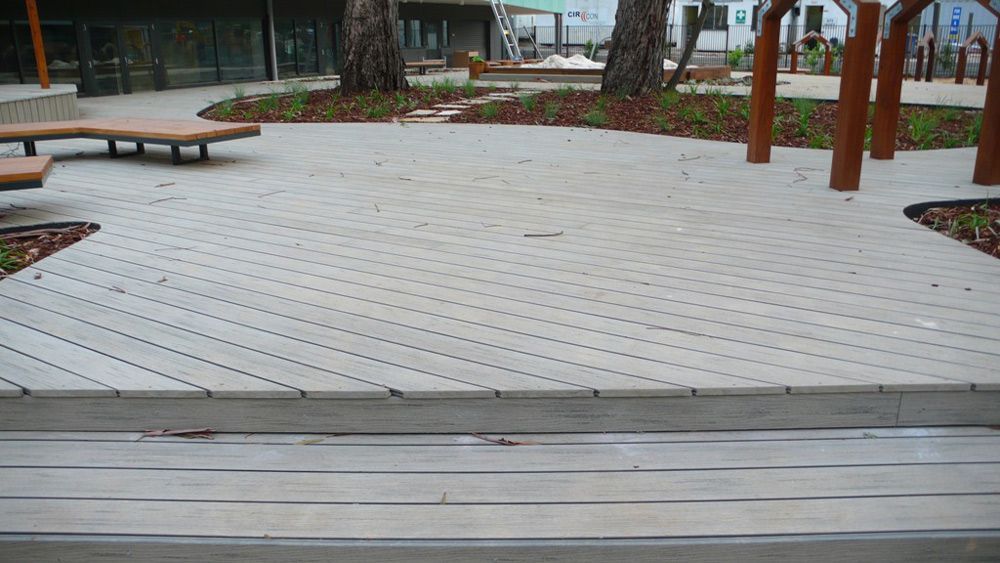 A Concrete Walkway With a Wooden Bench in the Background — B & B Timbers Ballina In West Ballina, NSW