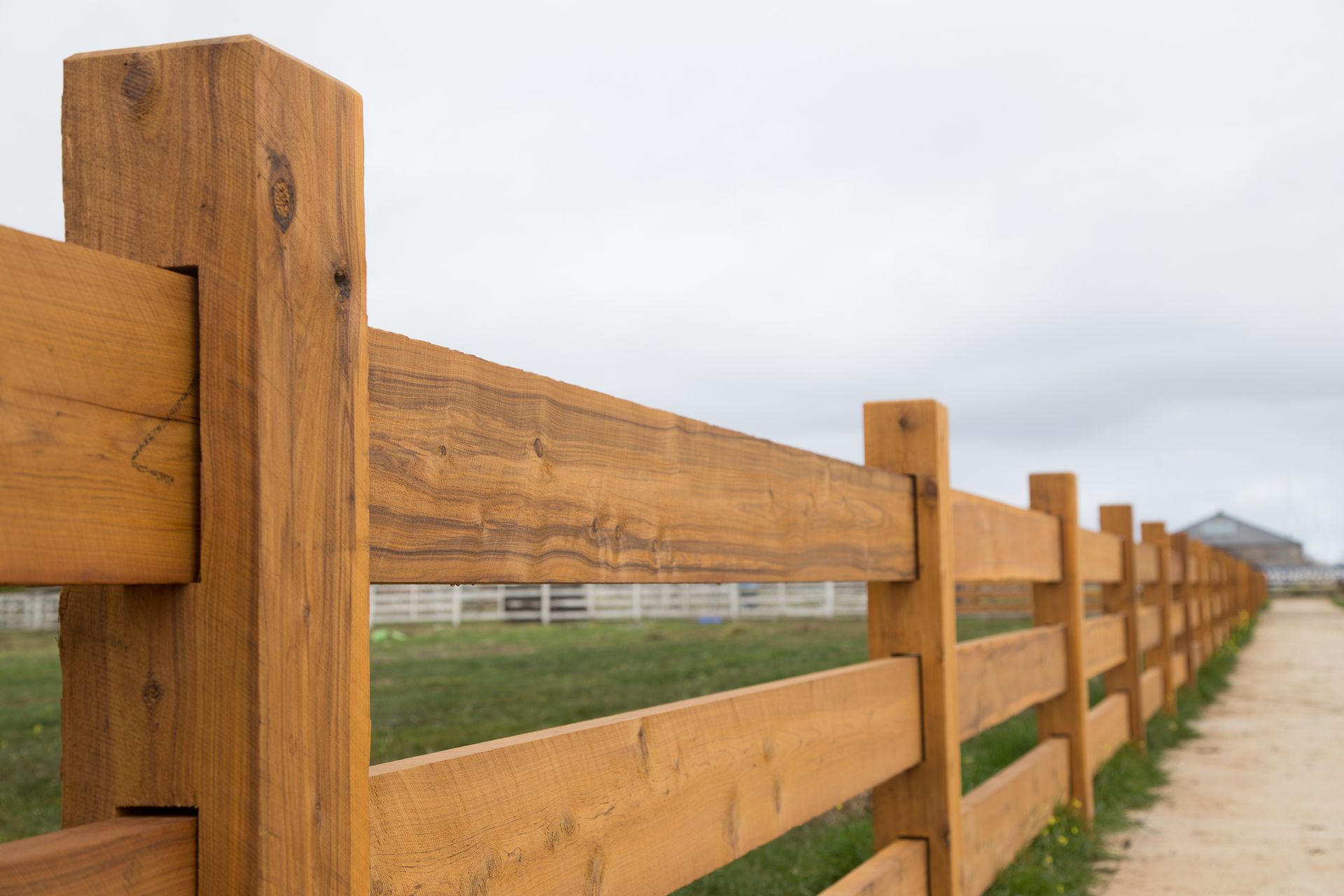A Wooden Fence Along a Dirt Road in a Field — B & B Timbers Ballina In West Ballina, NSW