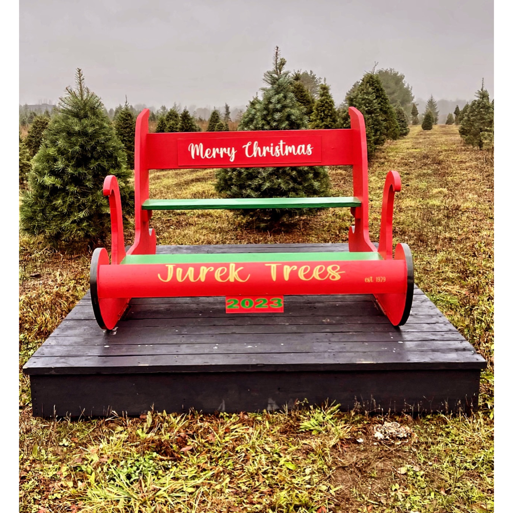 A red and green wooden bench labeled 
