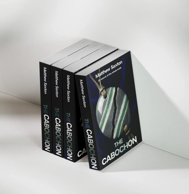 Paperback copies of The Cabochon by Matthew Saxton