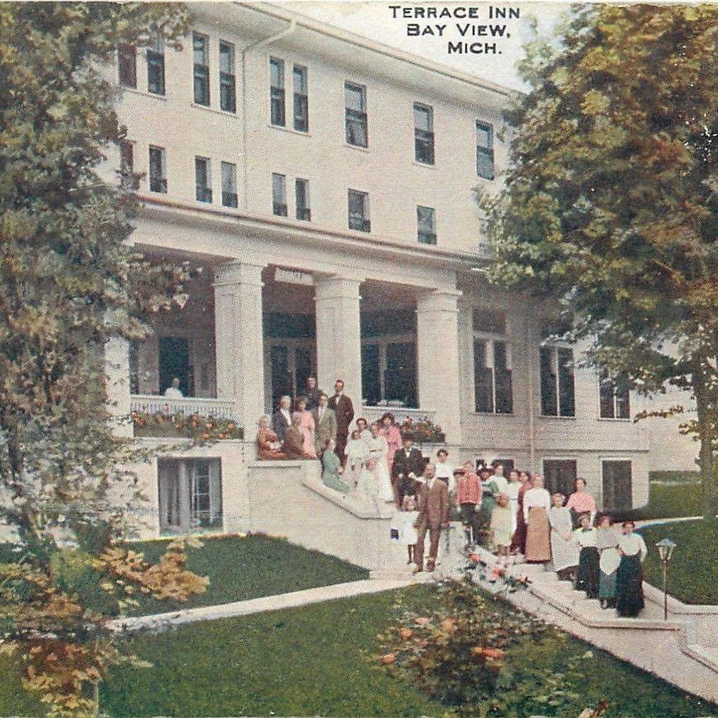 A group of people are gathered in front of the terrace inn bay view michigan