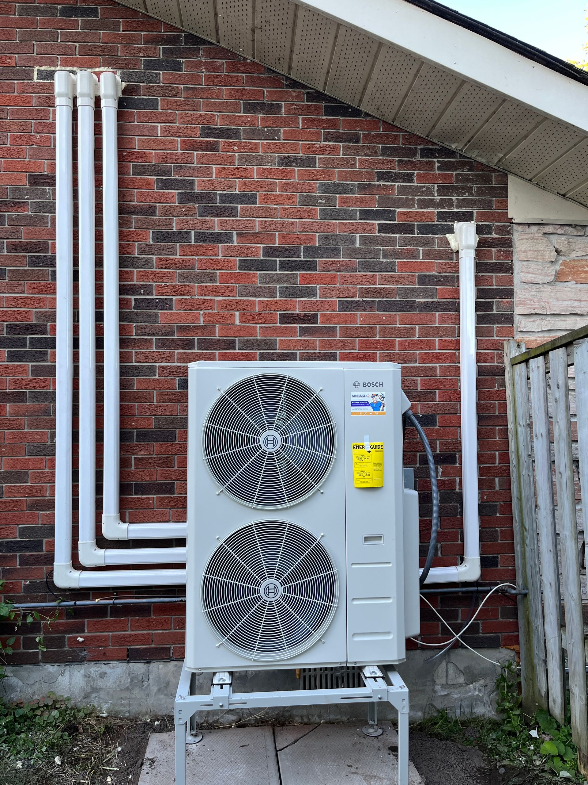 A man is installing an air conditioner on the wall.