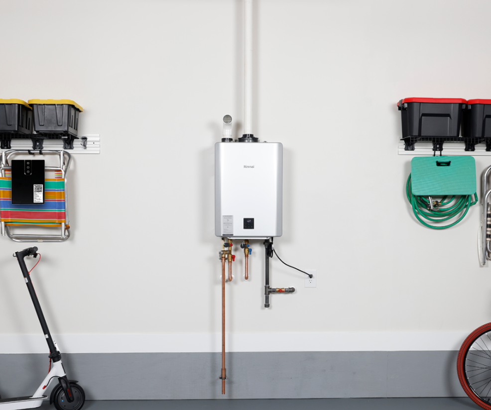 A scooter is sitting in a garage next to a bicycle and a water heater.