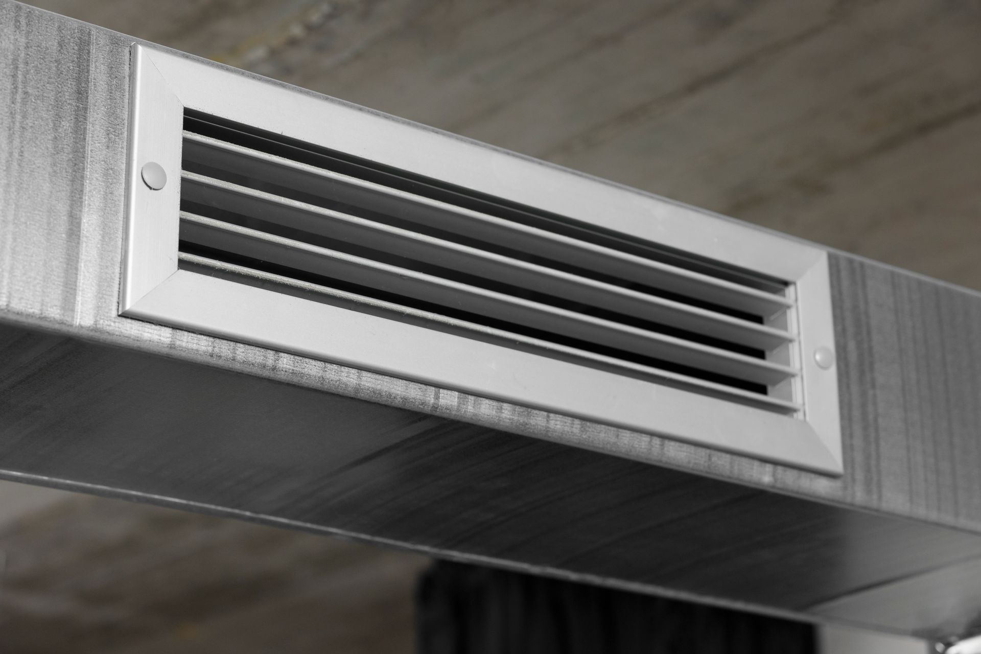 A close up of a metal duct with a vent on it