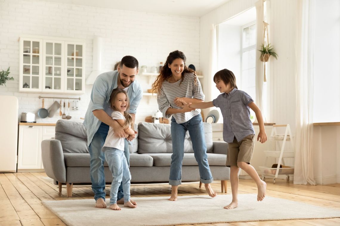A family is dancing together in a living room.