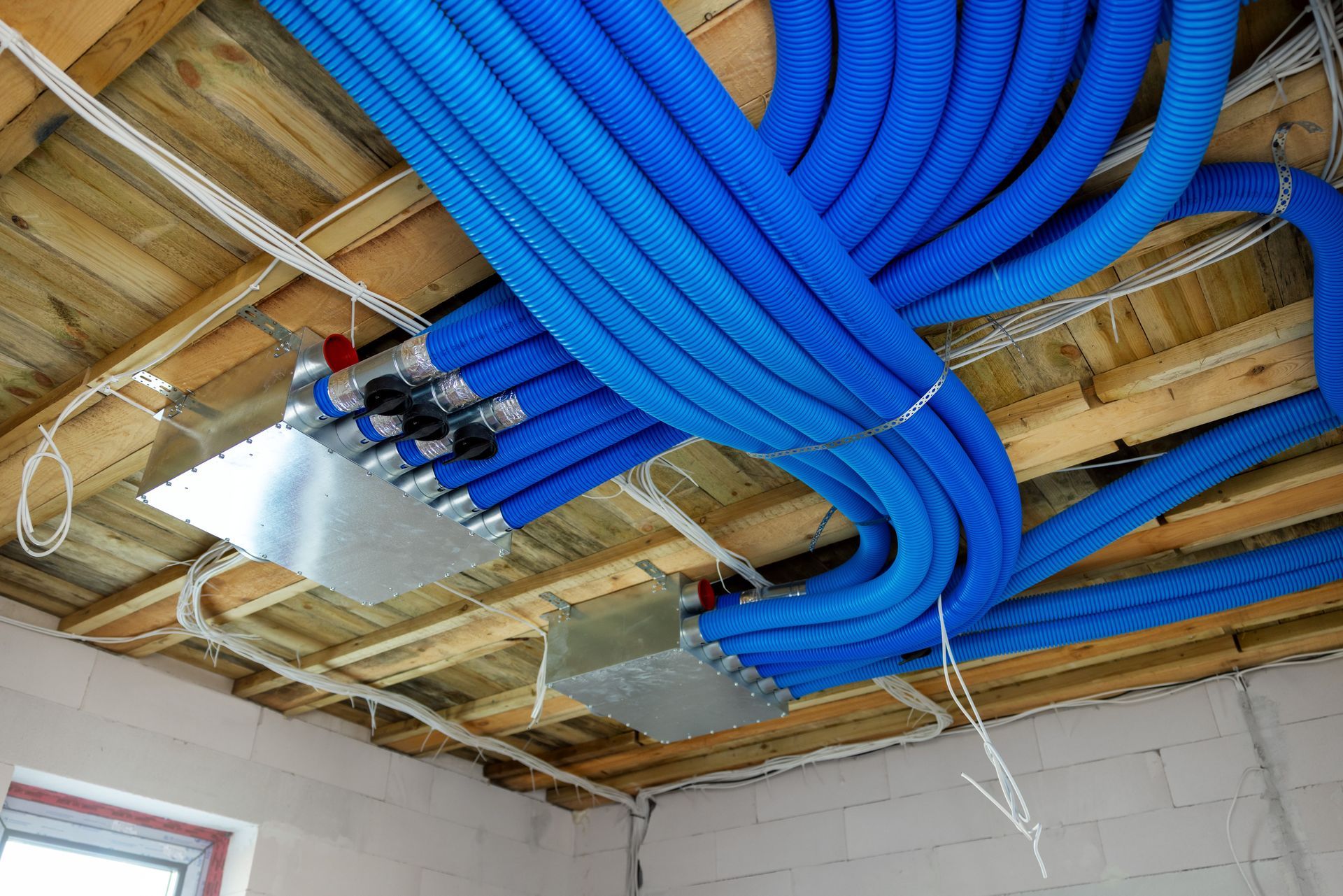A bunch of blue pipes are hanging from the ceiling of a building.