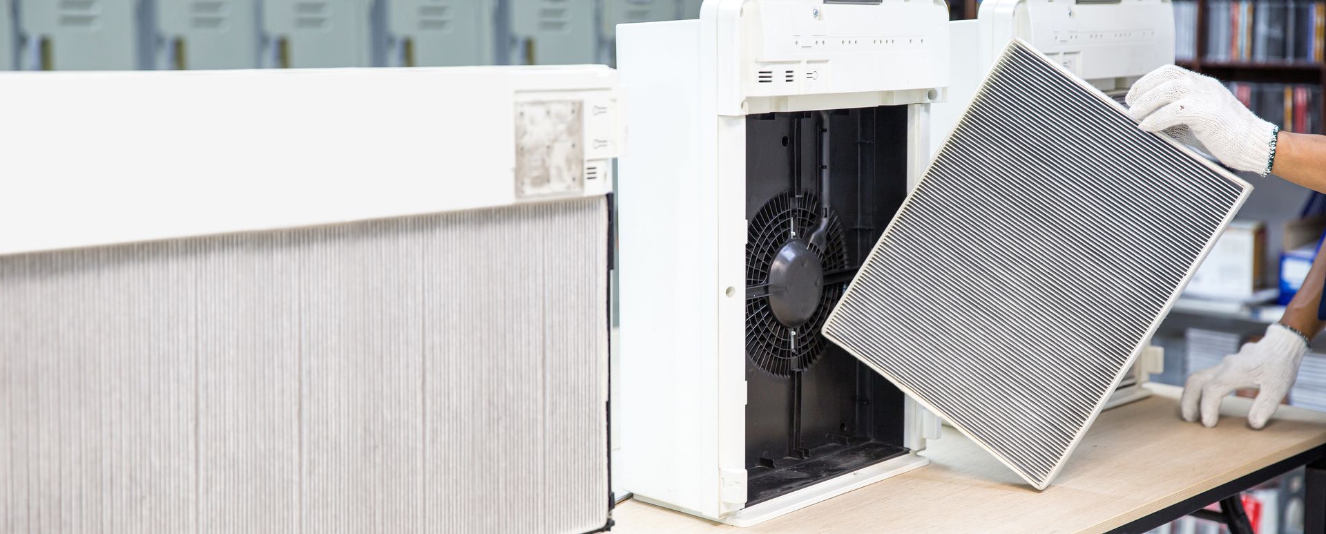 A person is taking a filter out of an air purifier.