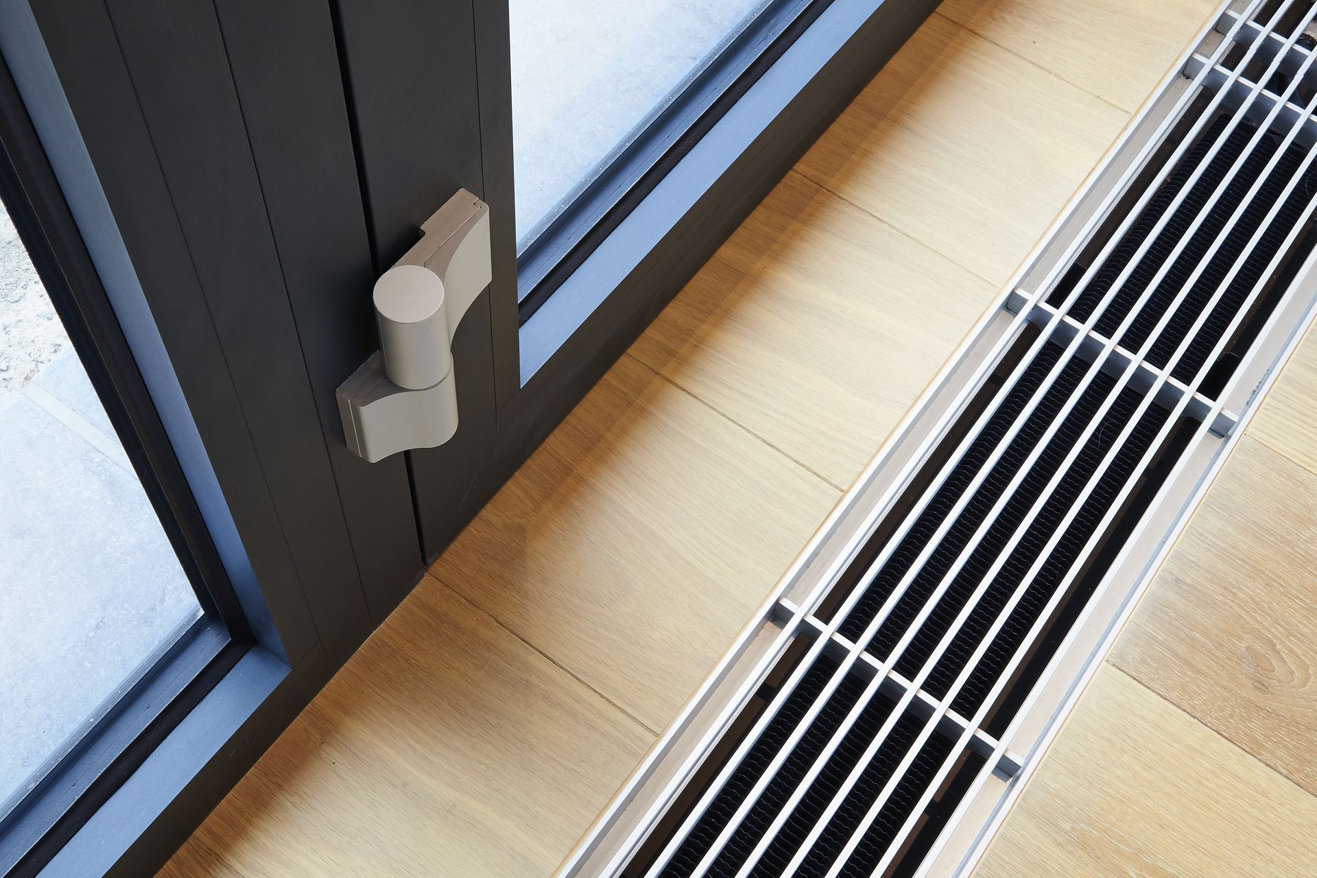 A sliding glass door with a stainless steel radiator underneath it