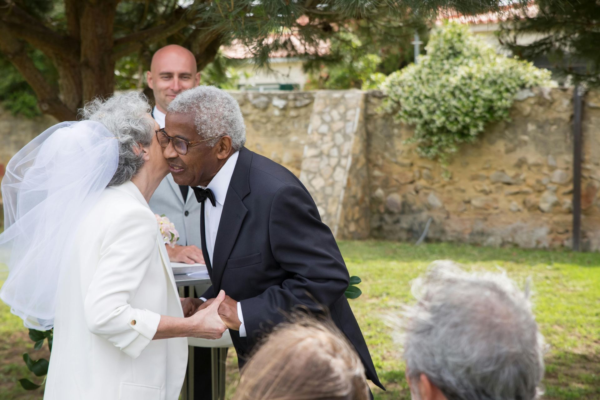 A bride and groom are holding hands during their wedding ceremony.