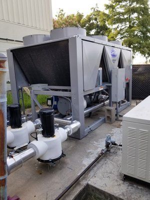 A large air conditioner is sitting on the side of a building.