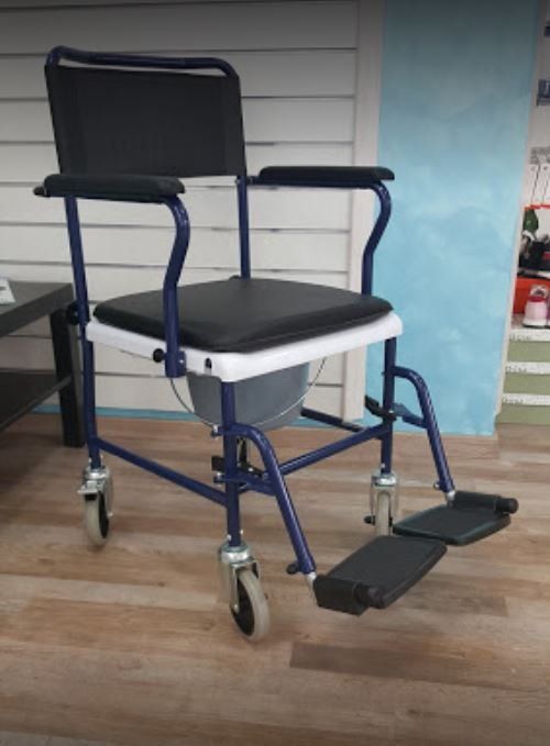 Sedia a rotelle blu con sedile e poggiapiedi neri su un pavimento di legno in un ambiente interno.