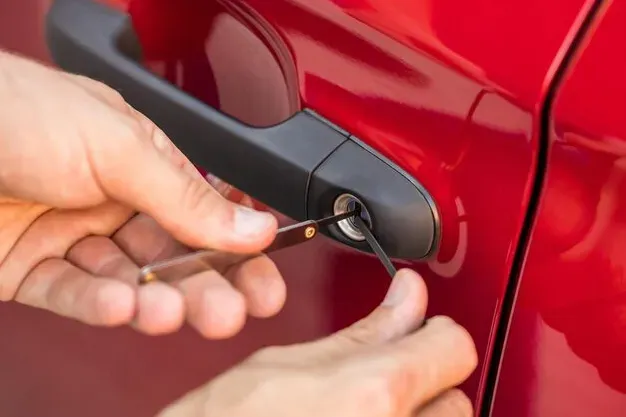 Hands using a key to unlock a red car door