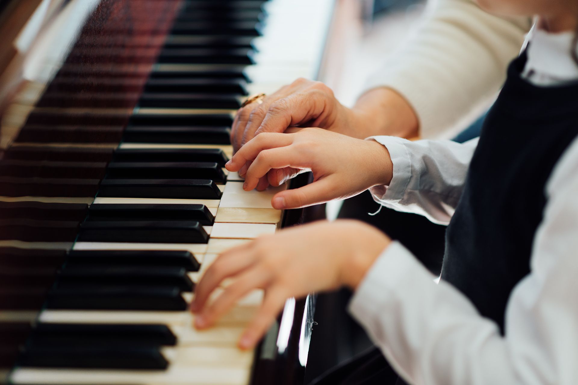Hands playing a piano keyboard in a close-up view Hands playing a piano keyboard in a close-up view
