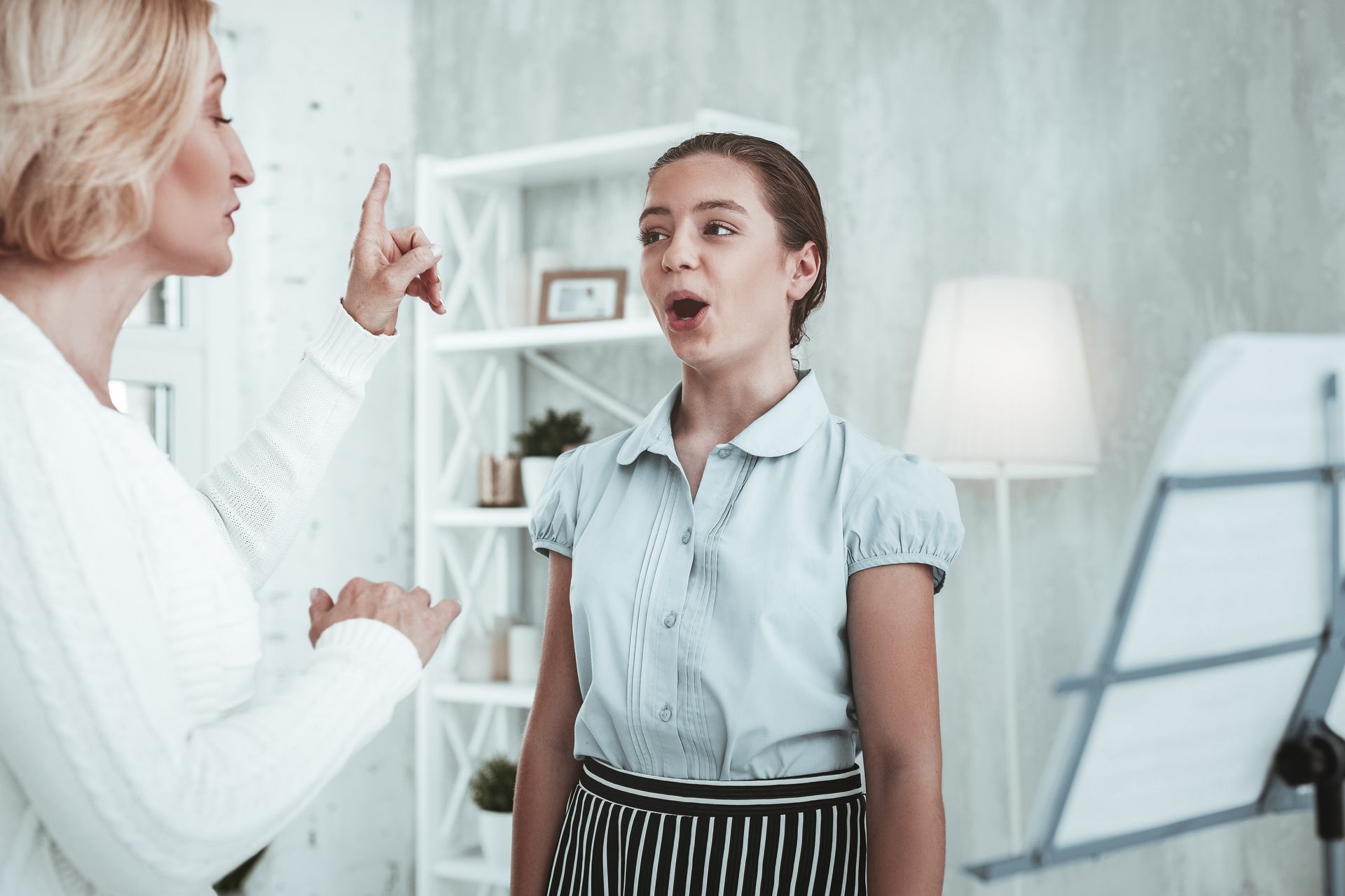 Two women talking in a bright office, one gesturing while the other listens near a whiteboard. Two women talking in a bright office, one gesturing while the other listens near a whiteboard.