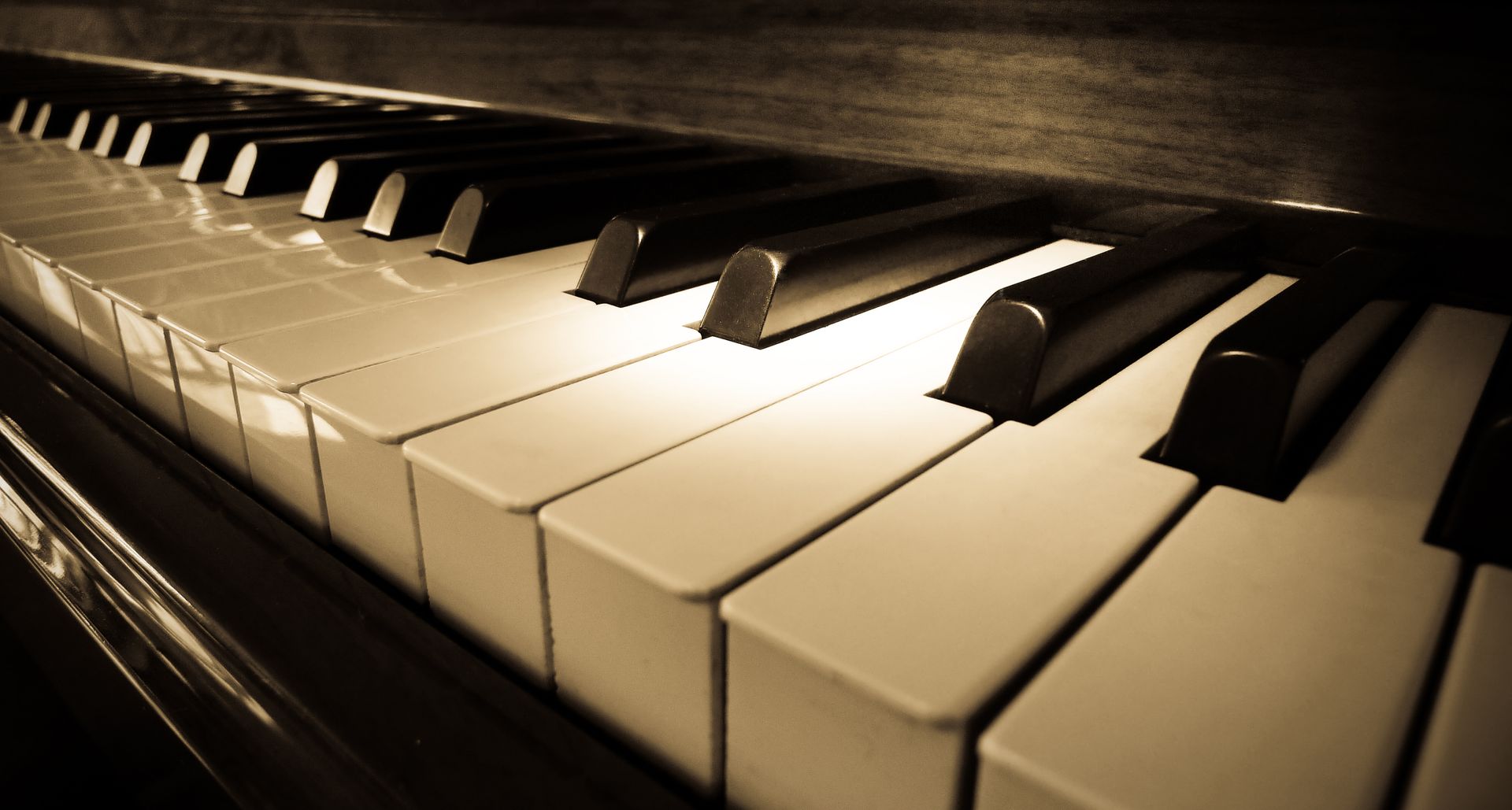 Close-up of piano keys in warm sepia light, viewed at an angle. Close-up of piano keys in warm sepia light, viewed at an angle.