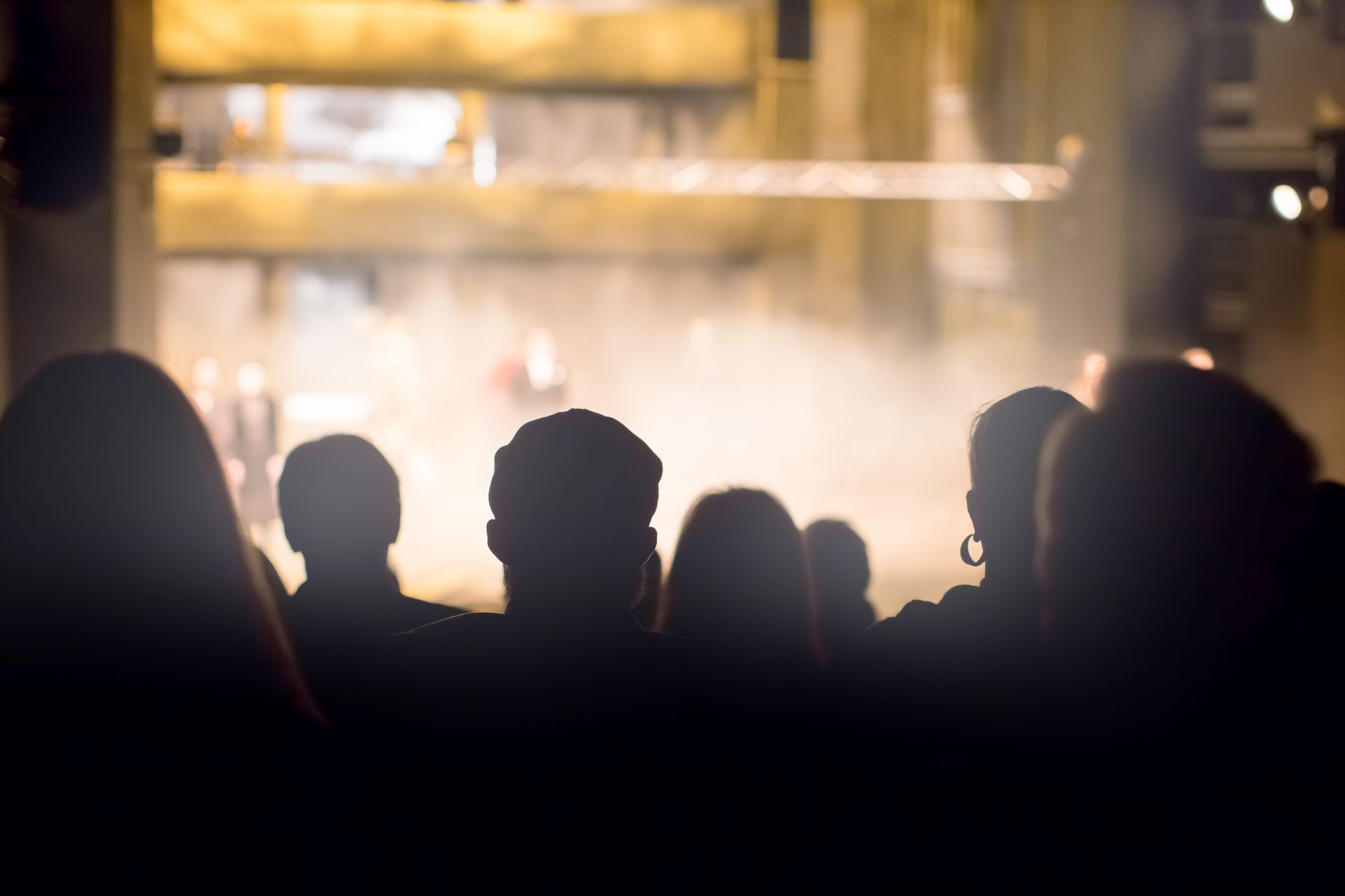 Silhouetted crowd watching a bright outdoor stage at night Silhouetted crowd watching a bright outdoor stage at night