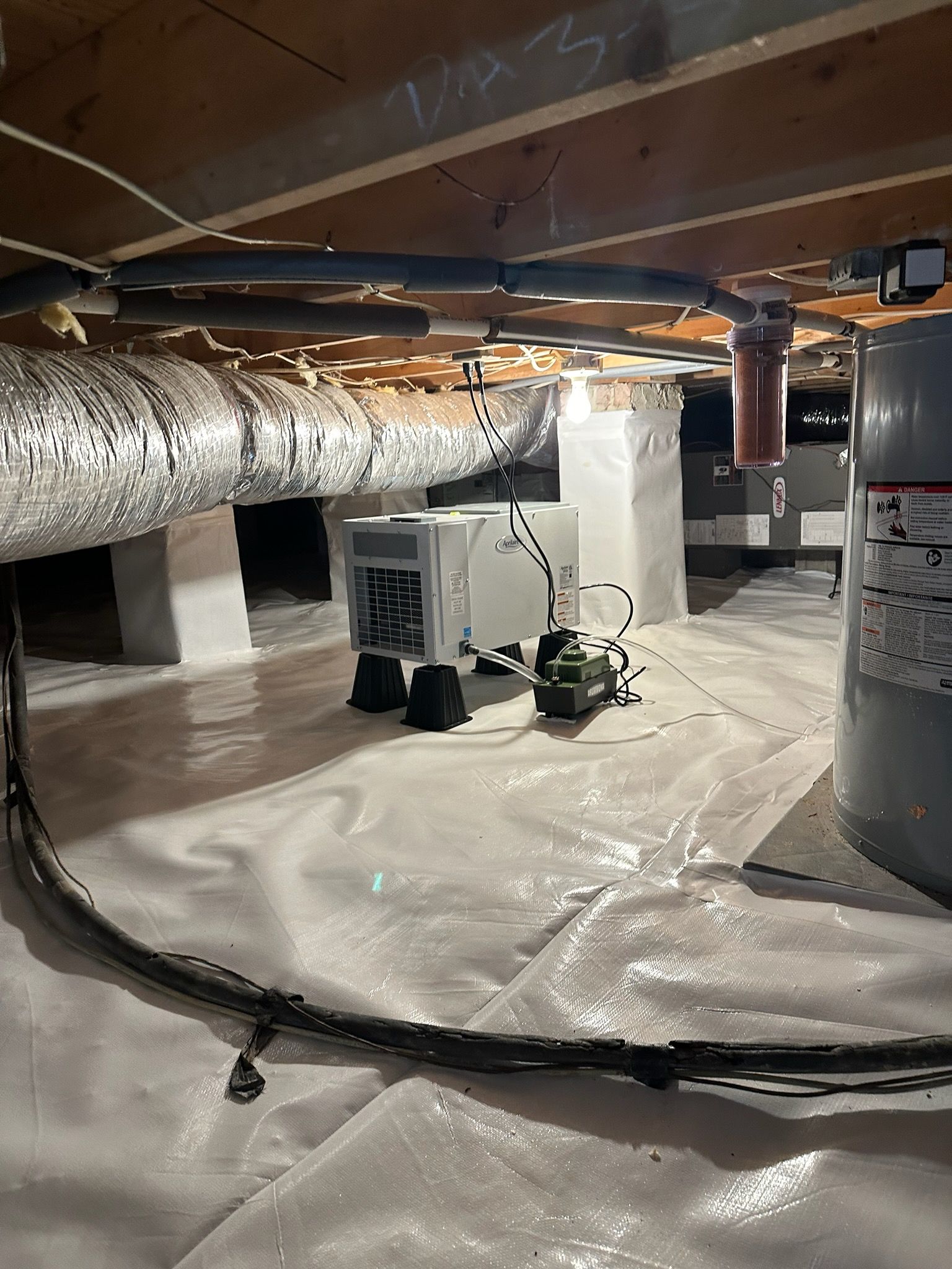 A basement with a lot of pipes and a water heater.