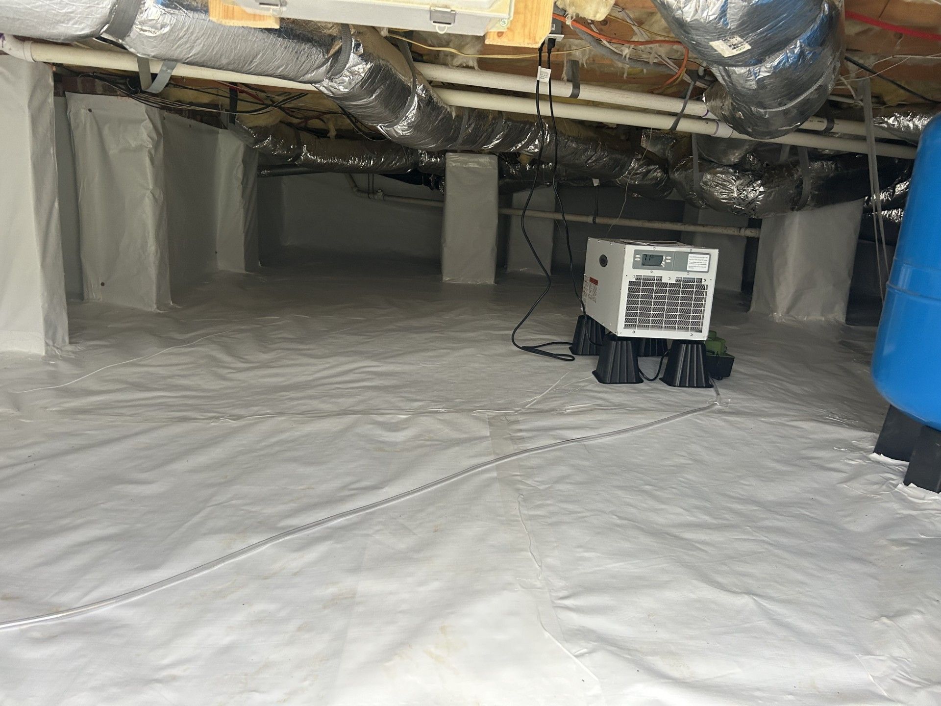 A humidifier is sitting on the floor of a basement.