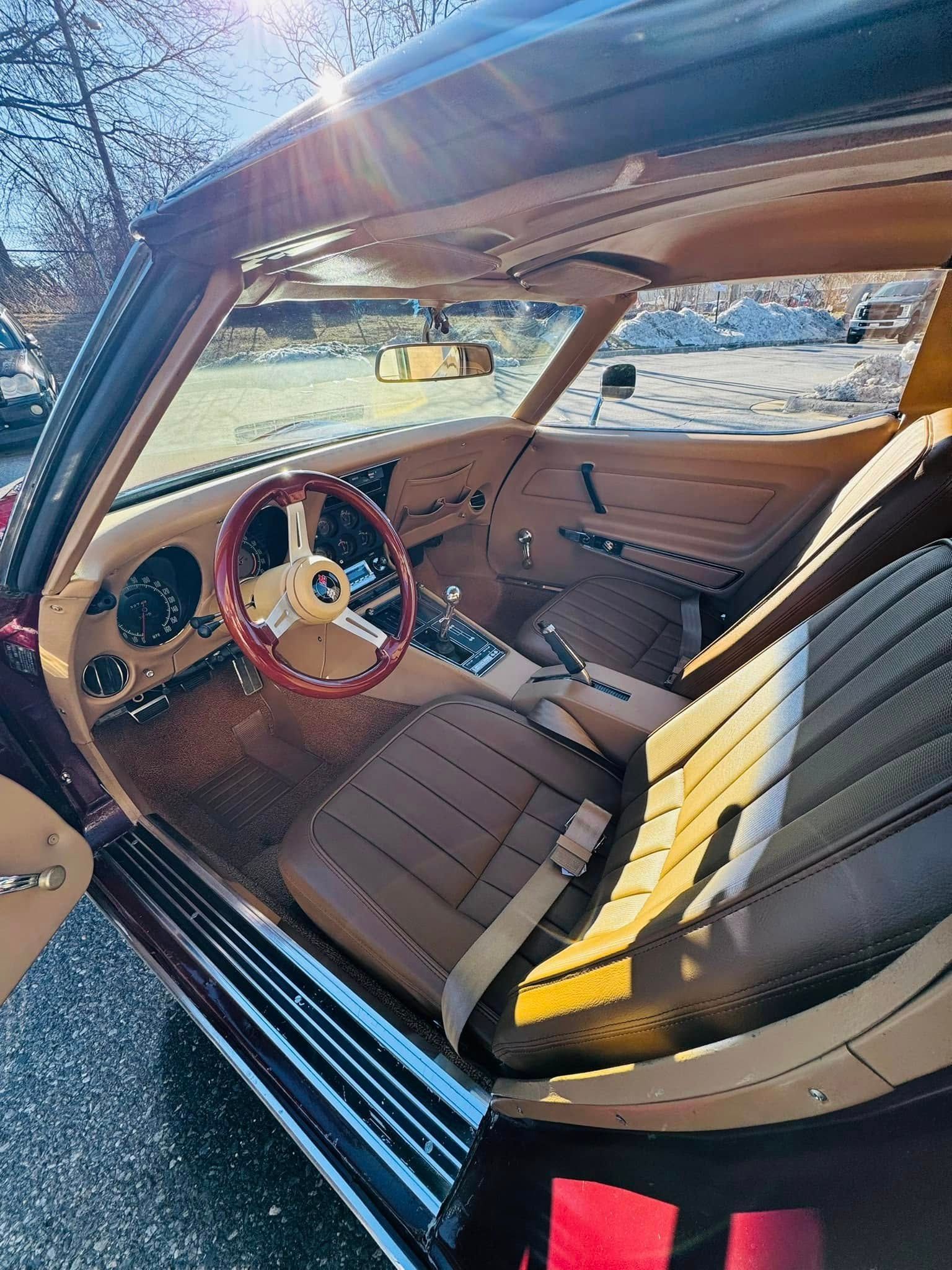 The inside of a car with the door open and the steering wheel visible.