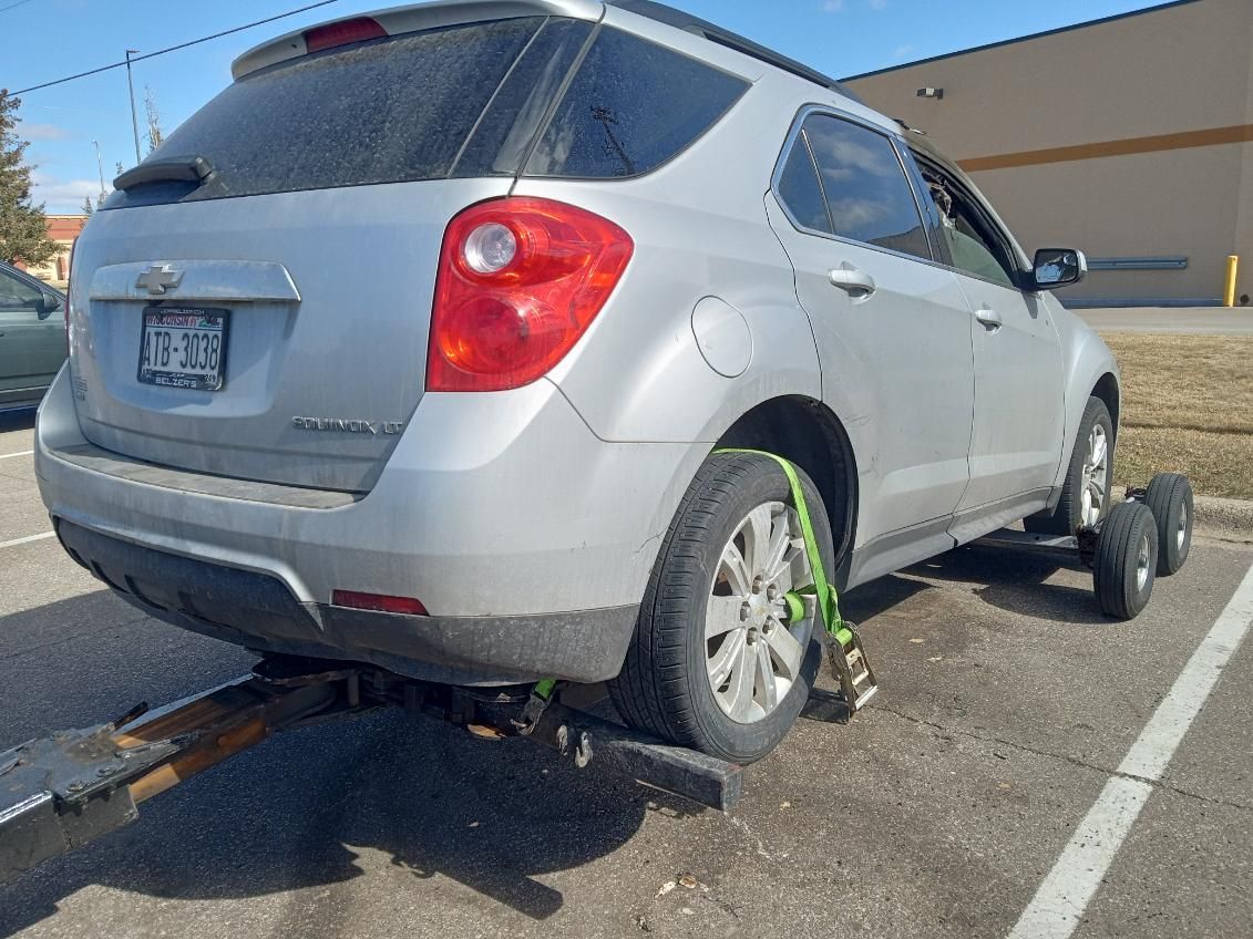 Silver SUV immobilized with wheel clamp in a parking lot