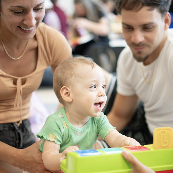 A woman and a man are playing with a baby