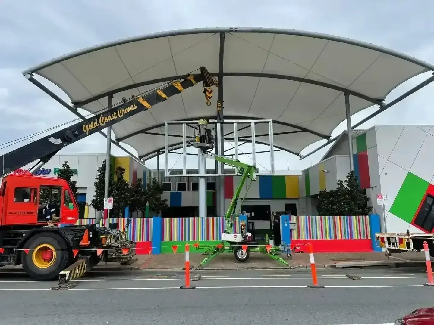 Mobile crane lifting a steel frame during commercial construction work