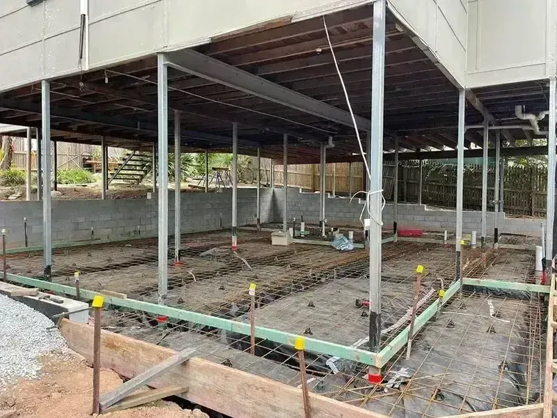 Steel reinforcement and formwork prepared for a concrete slab beneath a raised house