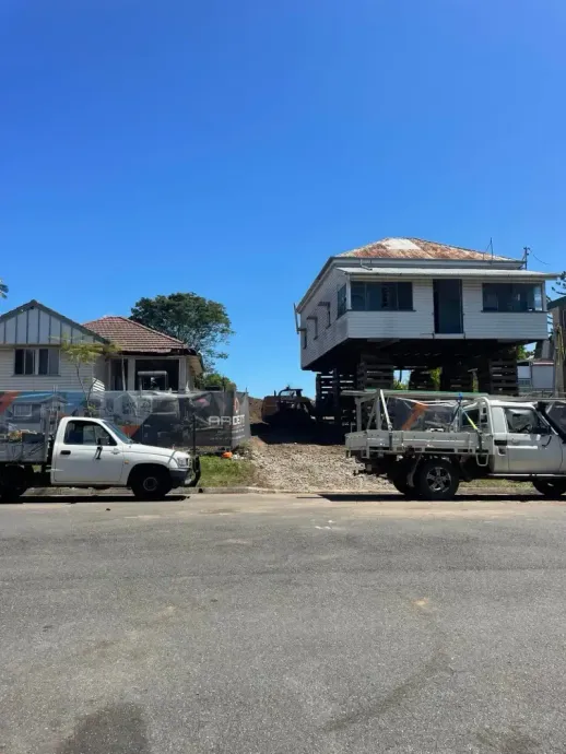 Raised timber house supported on temporary cribbing during house lifting work