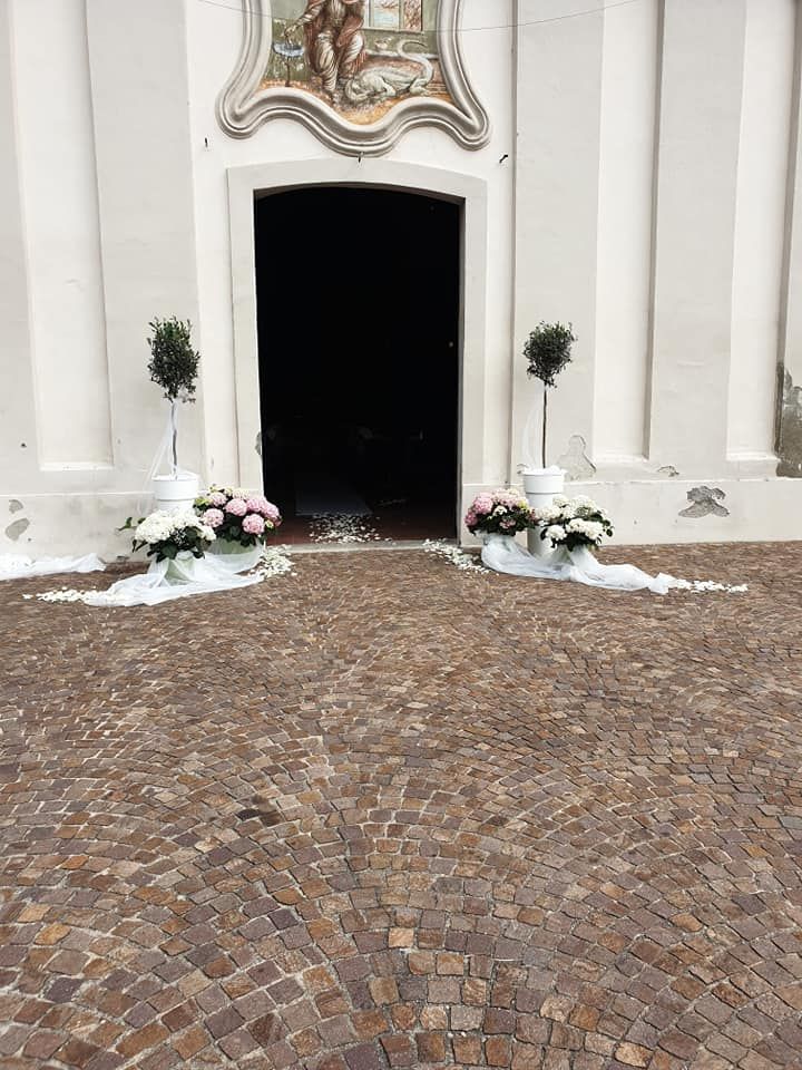 L'ingresso di una chiesa è decorato con fiori e alberi.