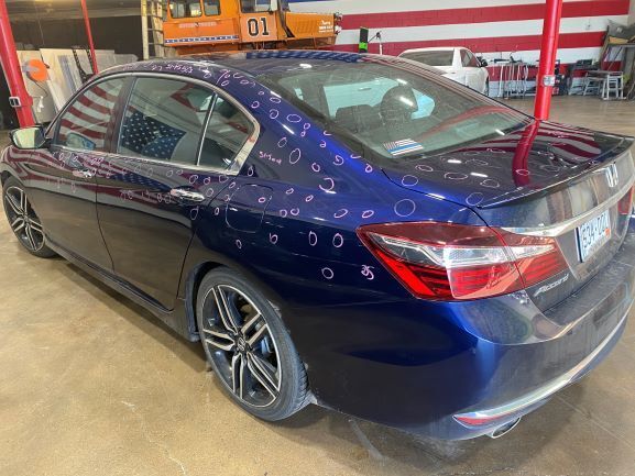 Blue sedan parked indoors with a large number 1 decal on the rear window