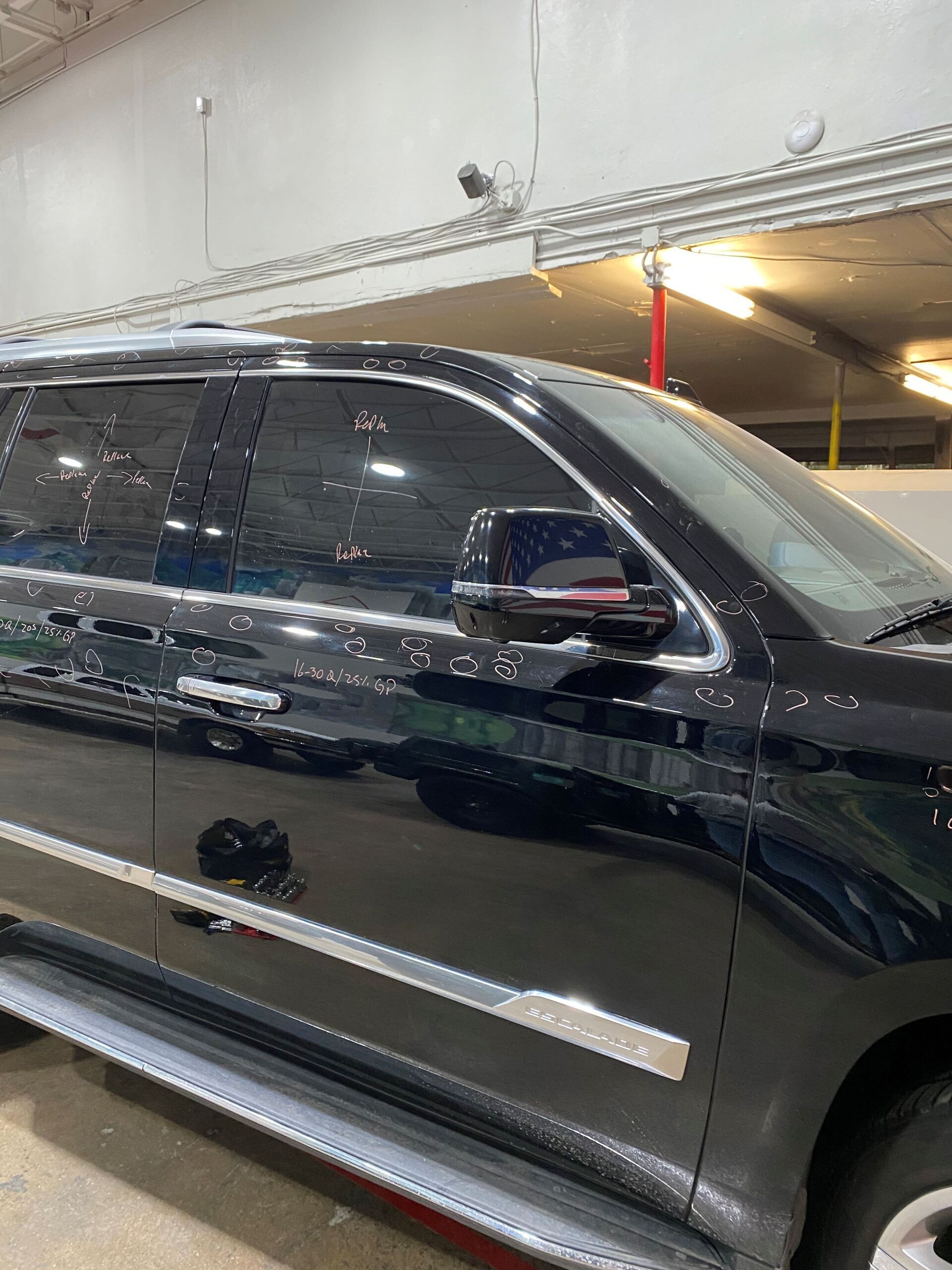 Black SUV parked in a garage, side view with chrome trim.