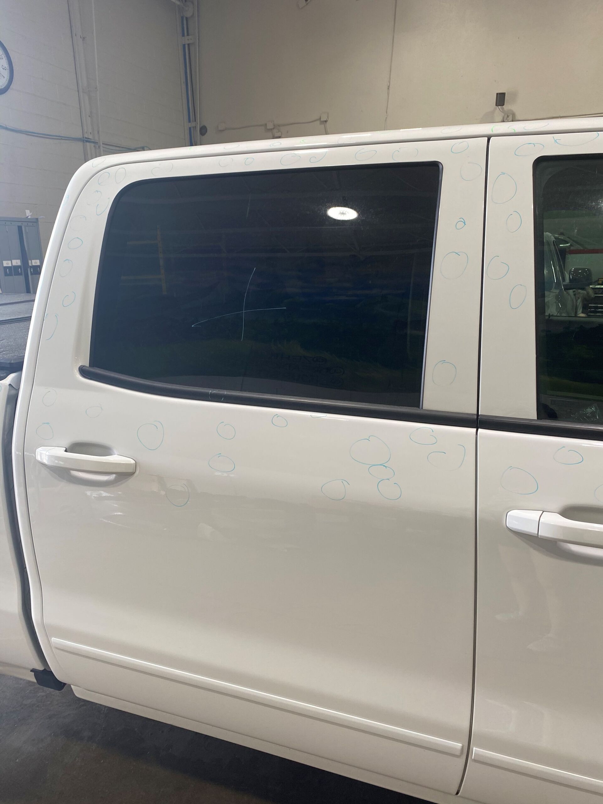 White pickup truck side door and tinted rear window inside a garage