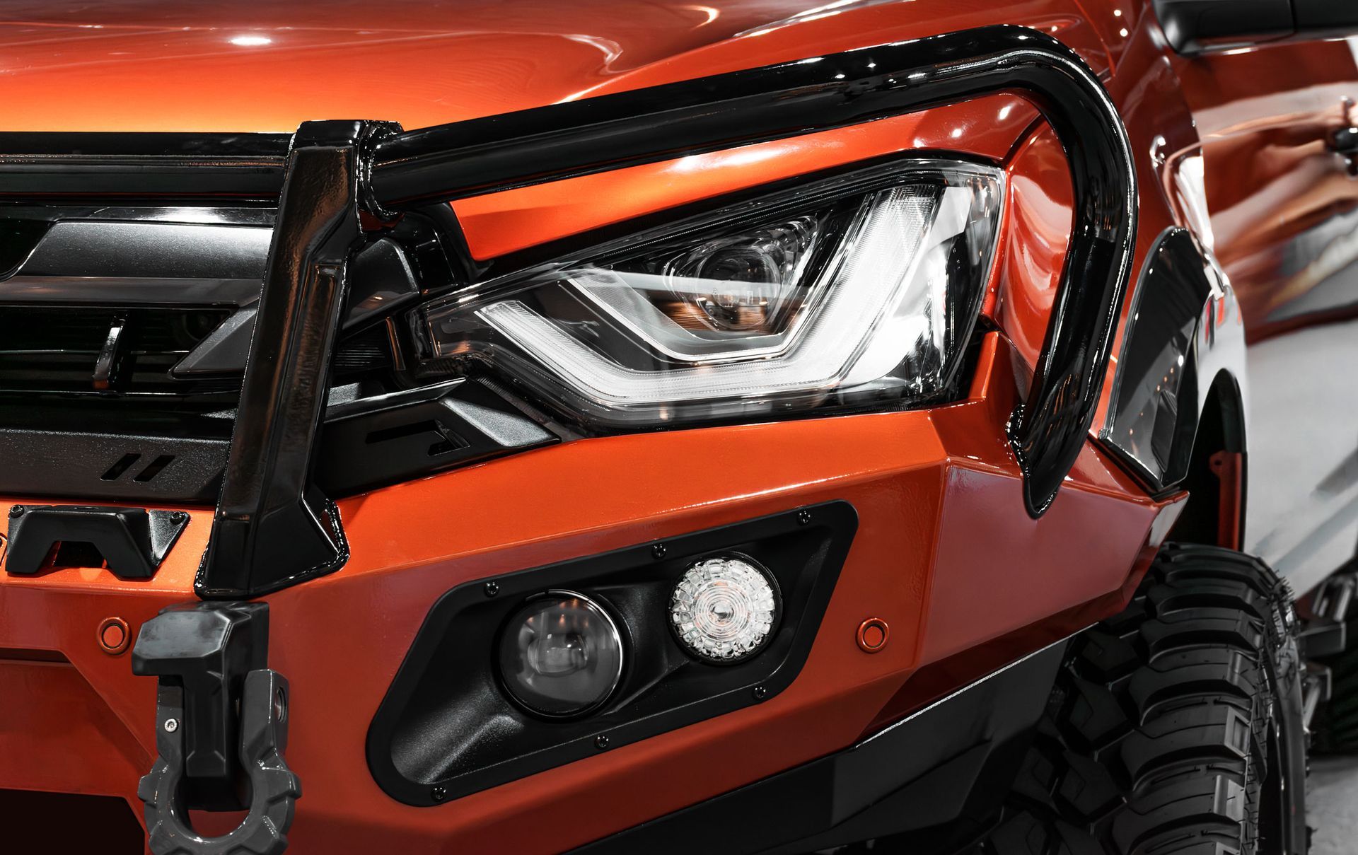 Orange truck with black bull bar, headlight, and bumper with tow hook. Orange truck with black bull bar, headlight, and bumper with tow hook.